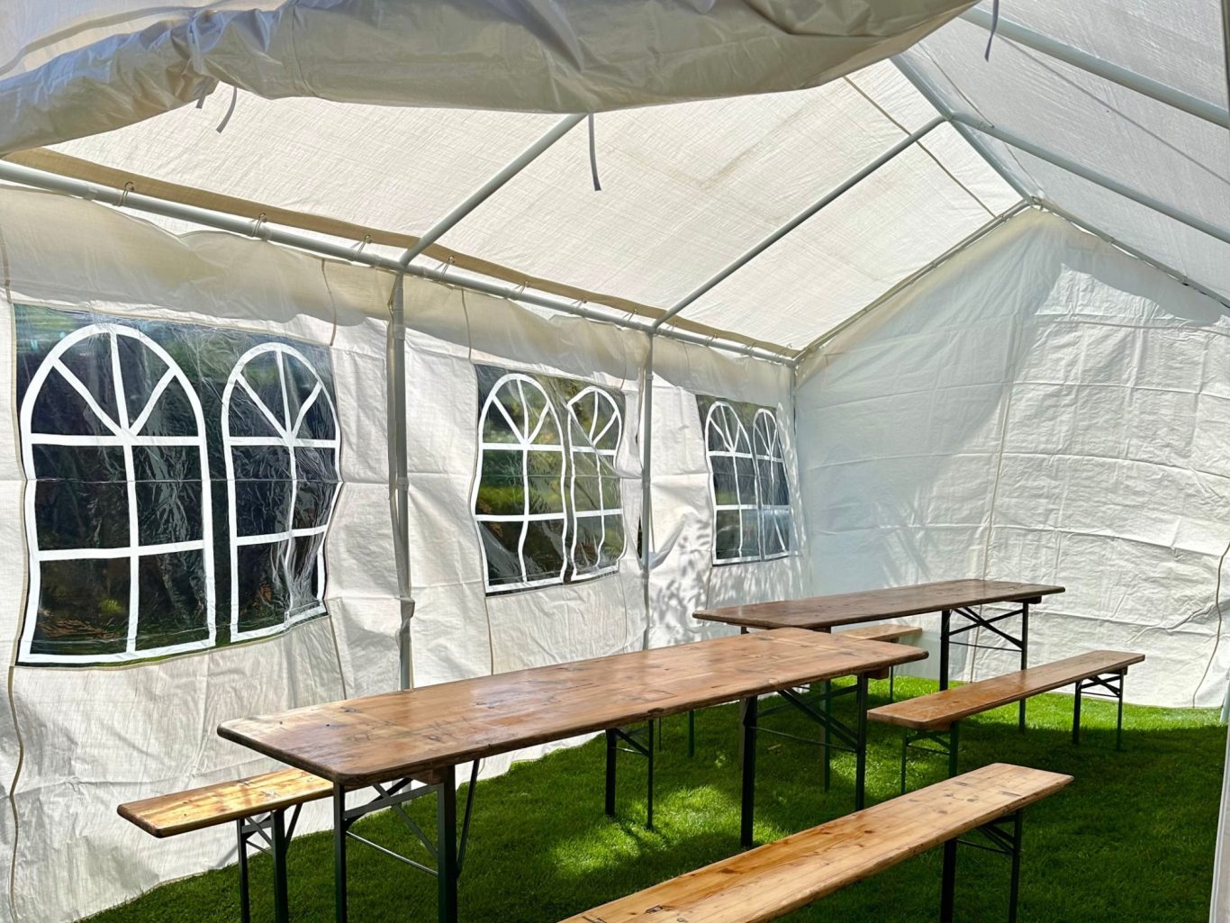 Witte partytent met tafels en banken Zwolle binnenkant witte partytent met biertafels Zwolle feest