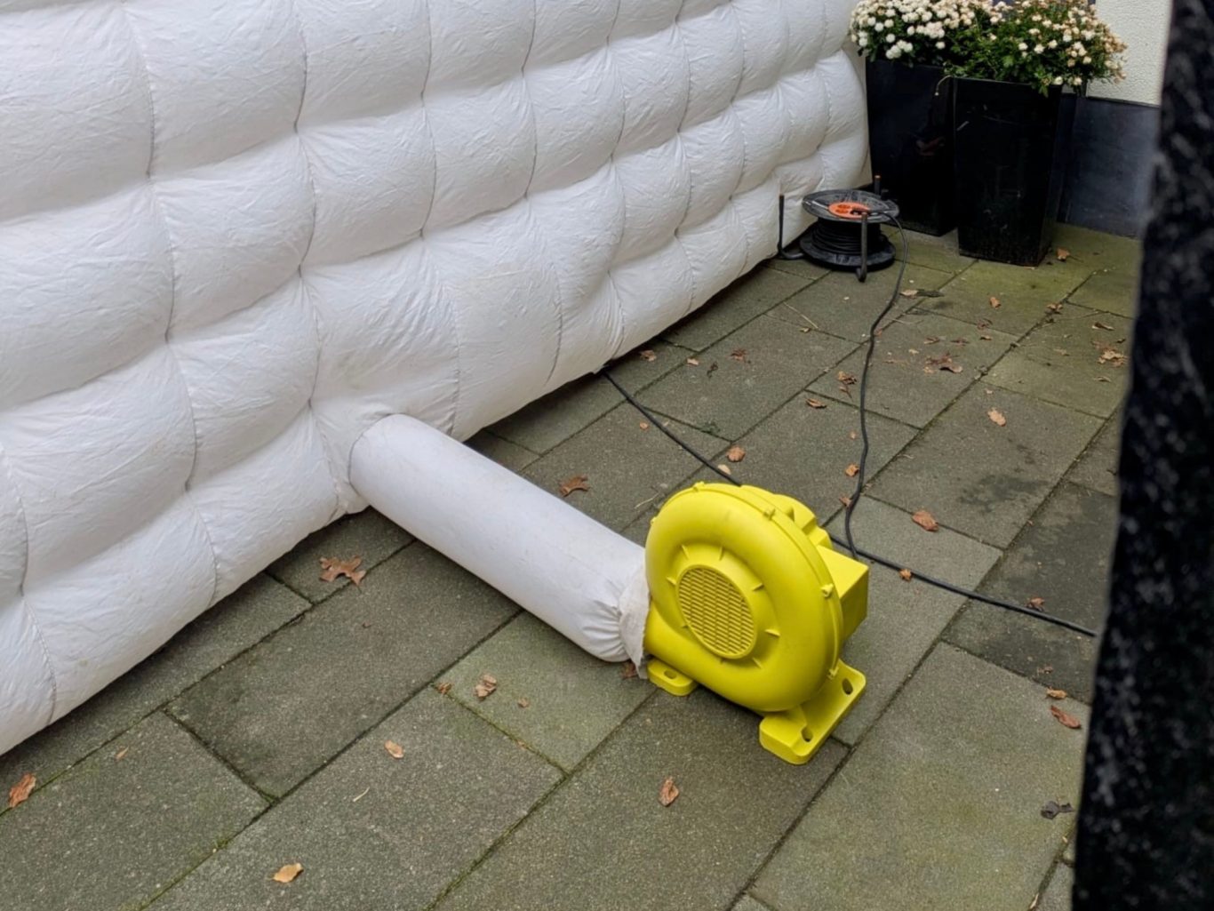 Blaasmachine om partytent op te blazen Gele luchtmachine om witte tent op te blazen.